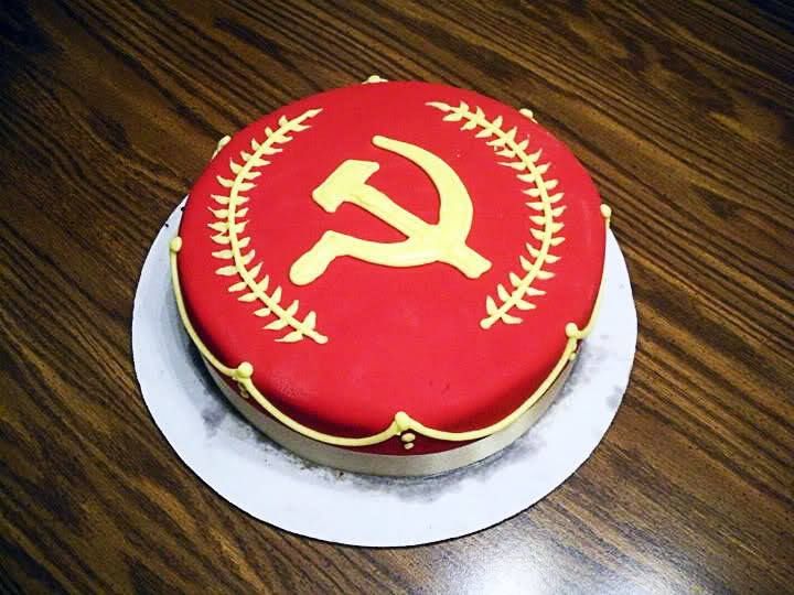 Cake with red icing and gold hammer and sickle. 